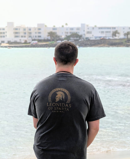 Person wearing a black t-shirt with 'Leonidas of Sparta' logo overlooking a body of water.